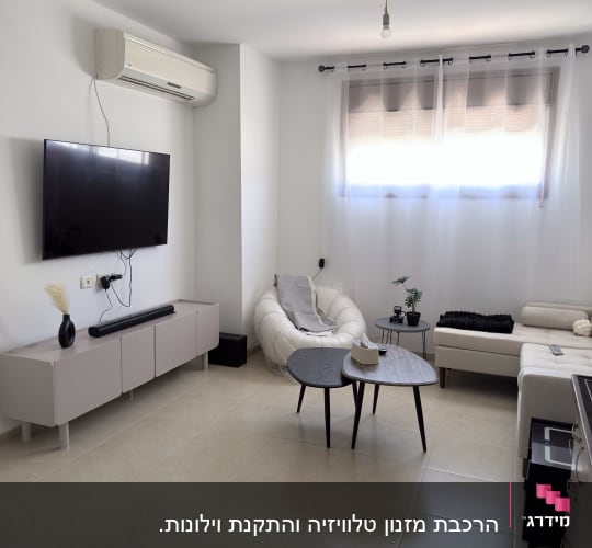 סלון עם טלוויזיה תלויה ומזגן על הקיר